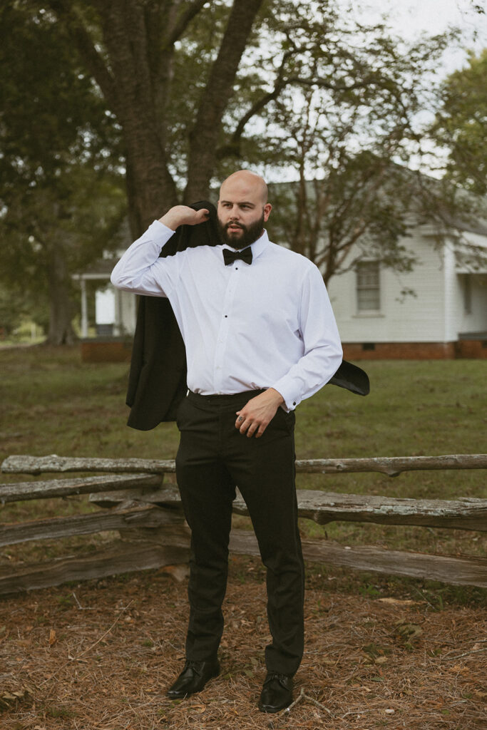 Man slinging suit jacket over his shoulder.