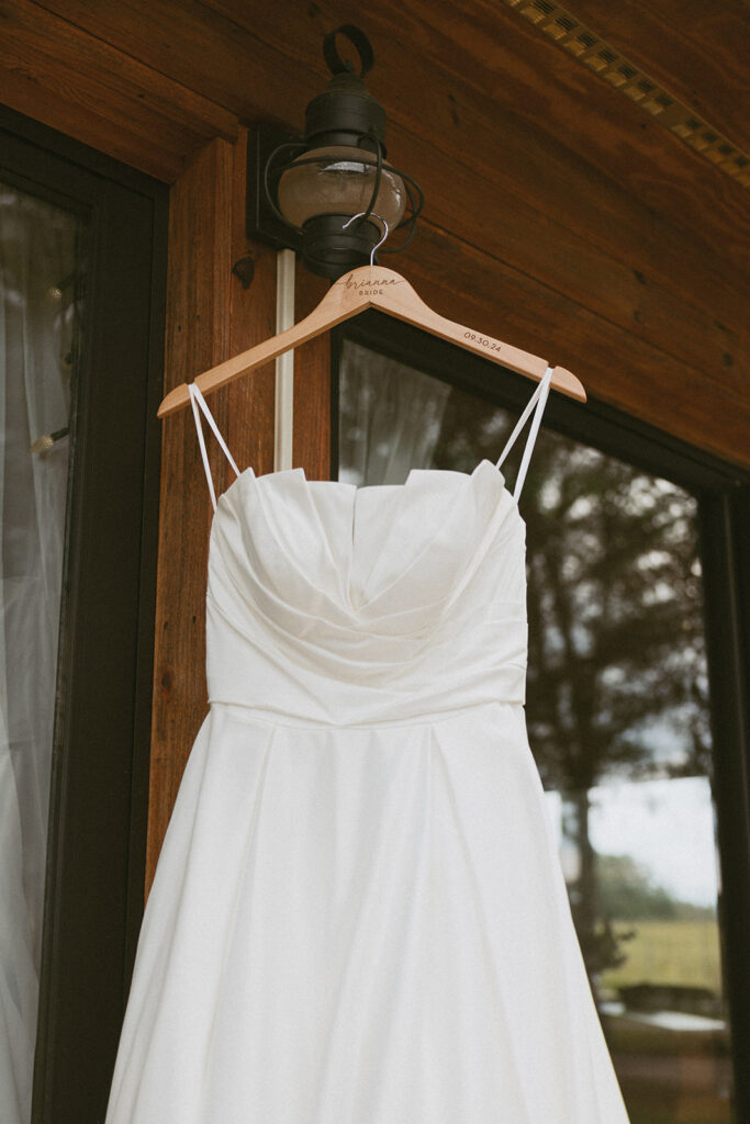 Wedding dress hanging on light at The Pavilion at Walker Century Farms.