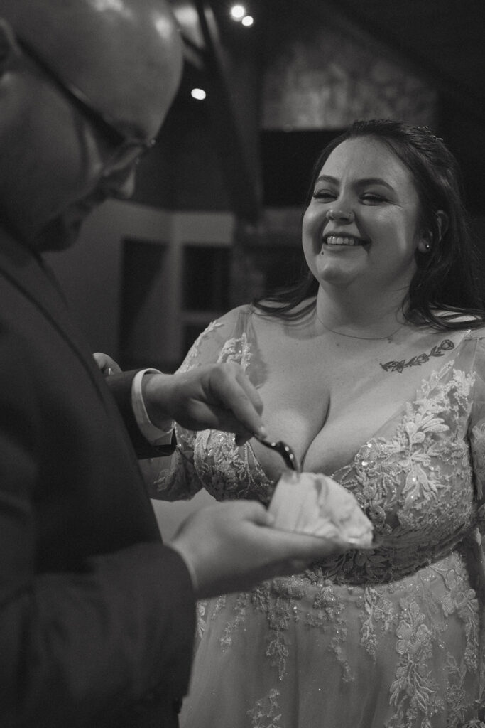 man about to feed woman cake at their wedding reception