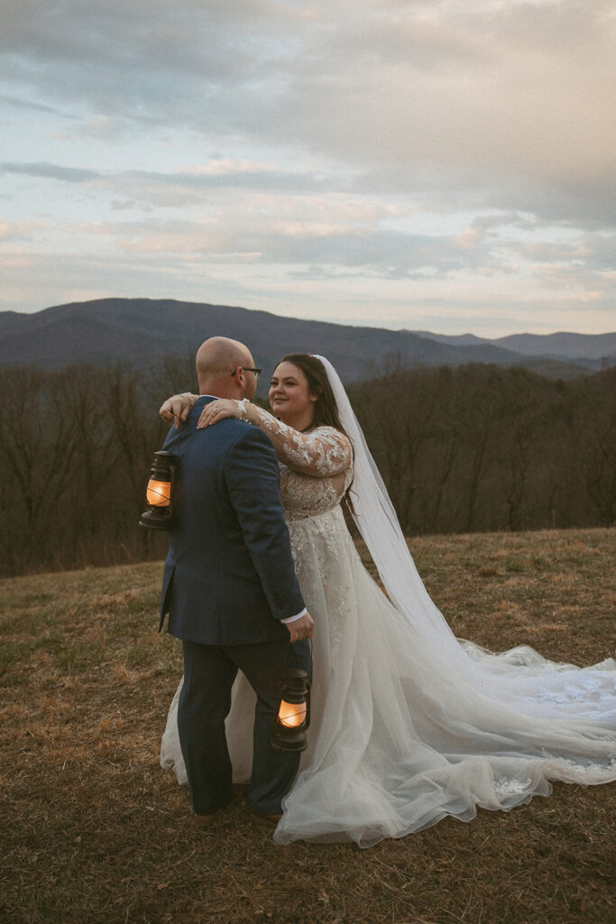 Man and woman in wedding attire, holding lanterns in the north georgia mountains