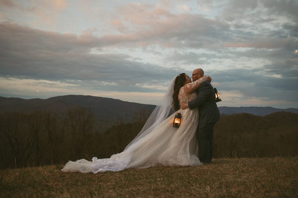 Man and woman in wedding attire, holding lanterns in the north georgia mountains