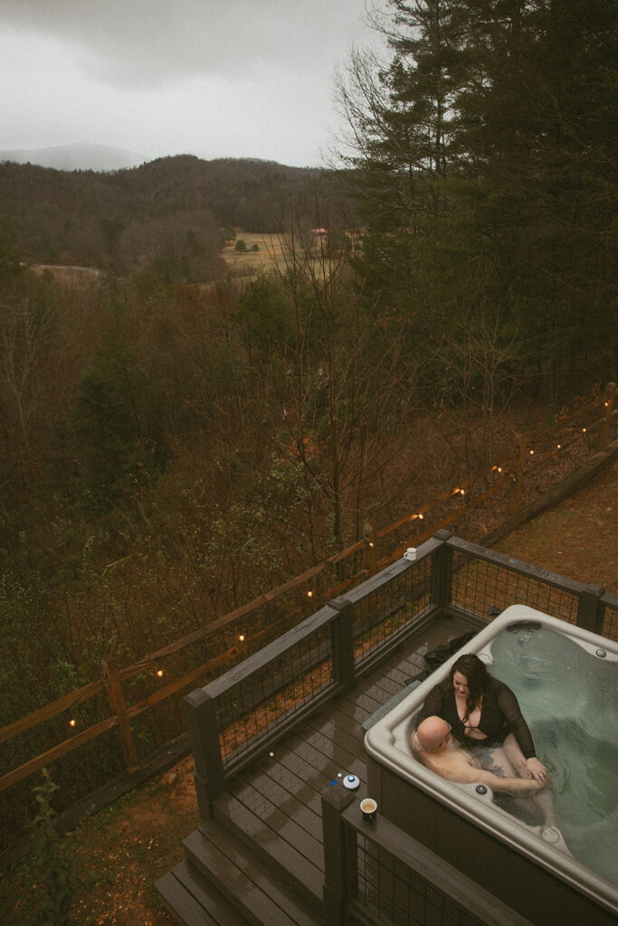 Man and woman in hot tub in the north georgia mountains the day after their elopement