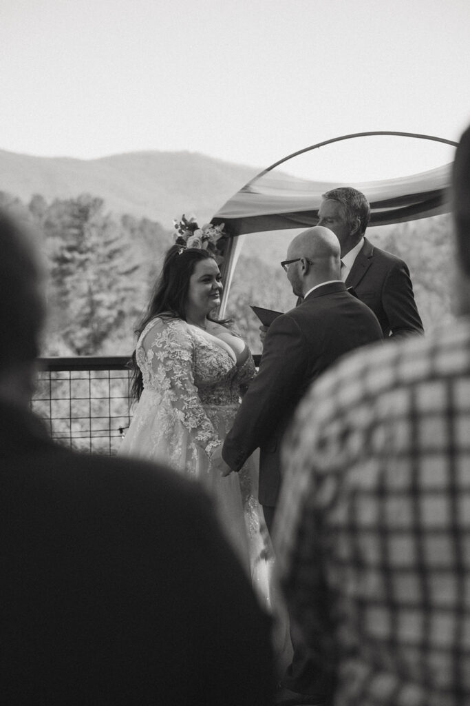 man and woman during wedding ceremony with mountains behind them.