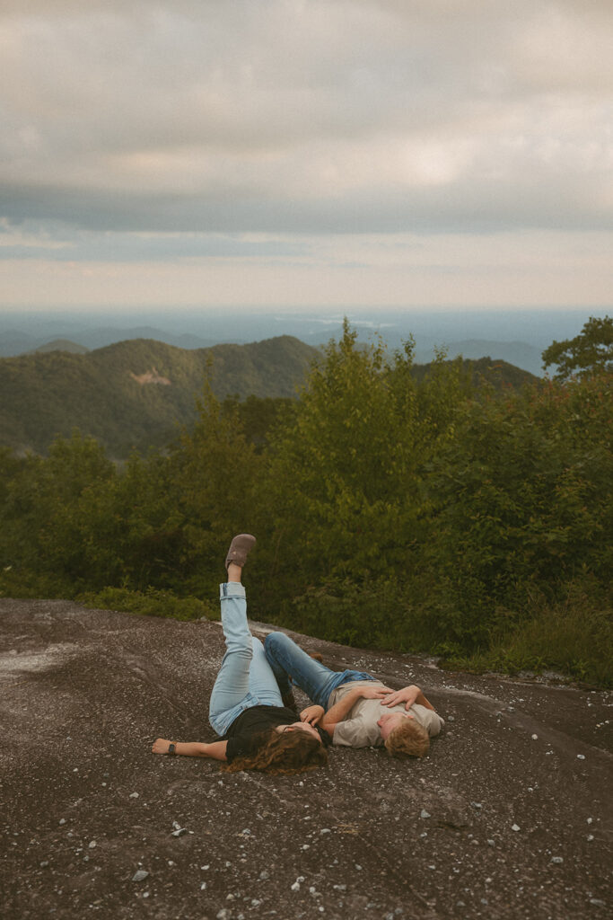 Man and woman laying on a rock at Sassafras Mountain.