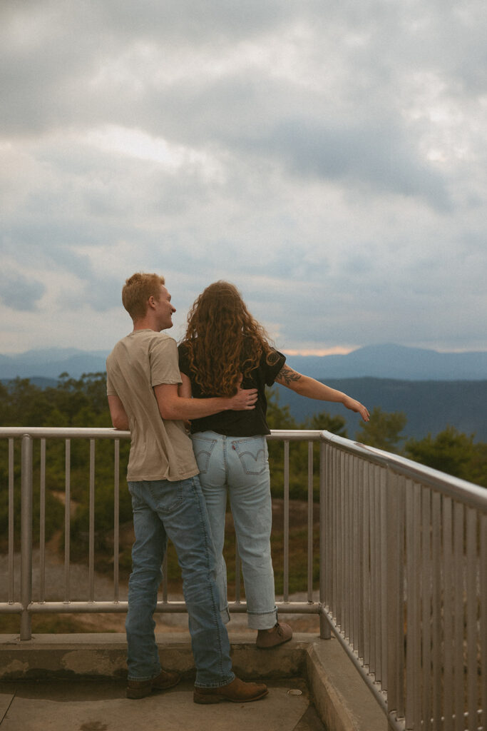 Man and woman looking at mountains from observation tower at Sassafras Mountain.