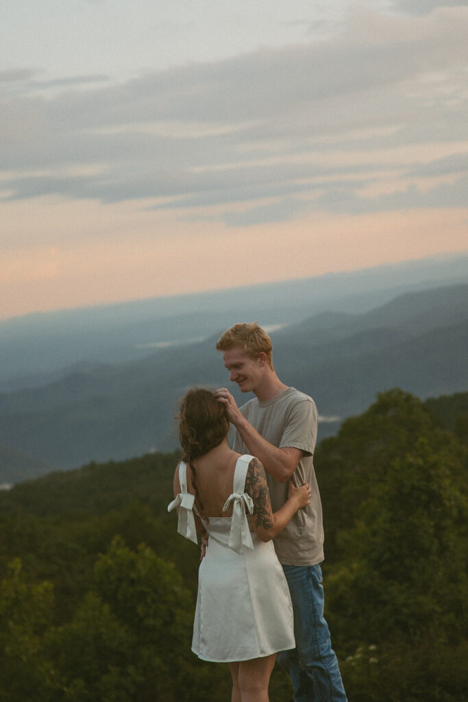 Man brushing hair behind womans ear at Sassafras Mountain.