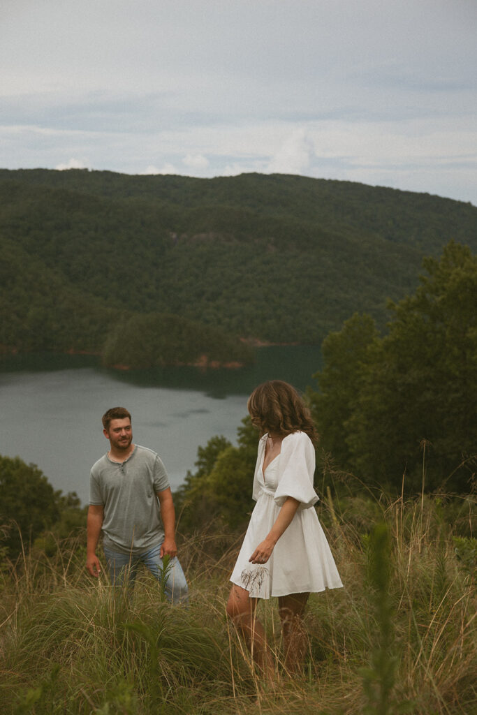 woman walking away from man and looking back at him smiling with mountains behind them