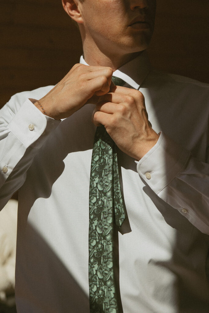 man putting on his tie for hiking elopement