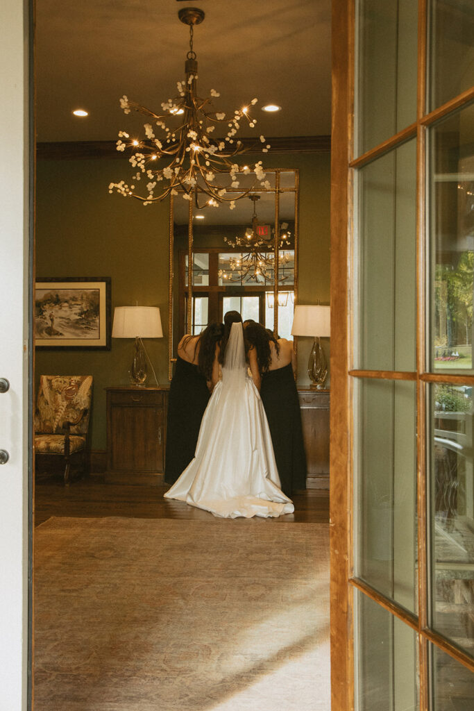 a bride with her two bridesmaids standing in doorway of trilliium links and lake club