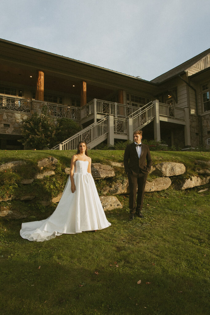 husband and wife standing in front of trillium links and lake club in cashiers nc