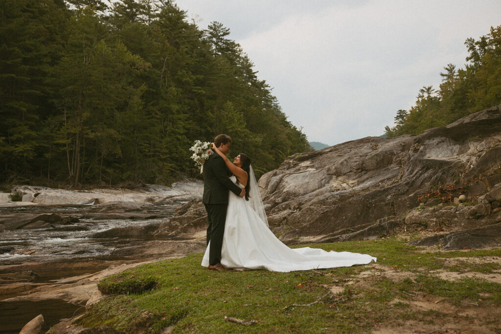 Husband and wife holding each other next to the creek at Brown Mountain Beach Resort.