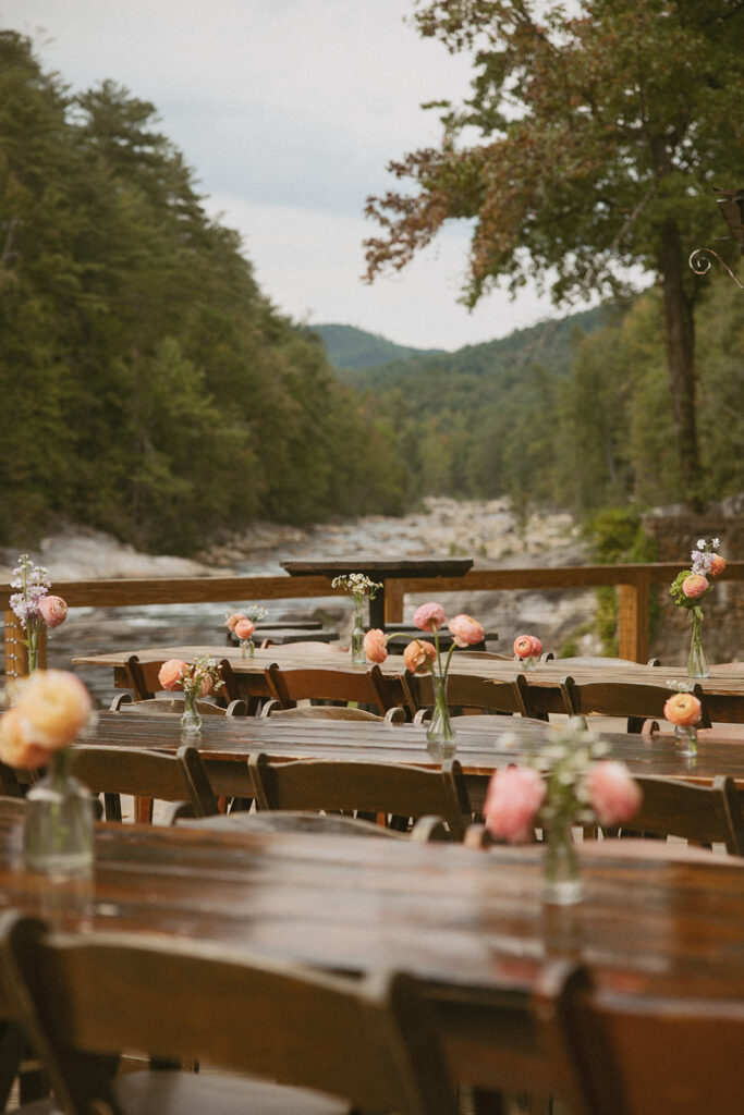 Tables with flowers and mountain behind them at Brown Mountain Beach Resort.