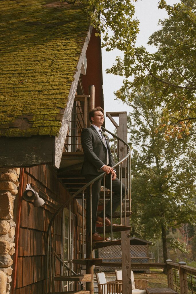 Groom standing on stairs of his cabin on his wedding day at Brown Mountain Beach Resort.