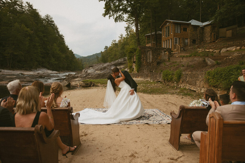 husband and wife kissing during their Creekside ceremony at Brown Mountain Beach Resort.